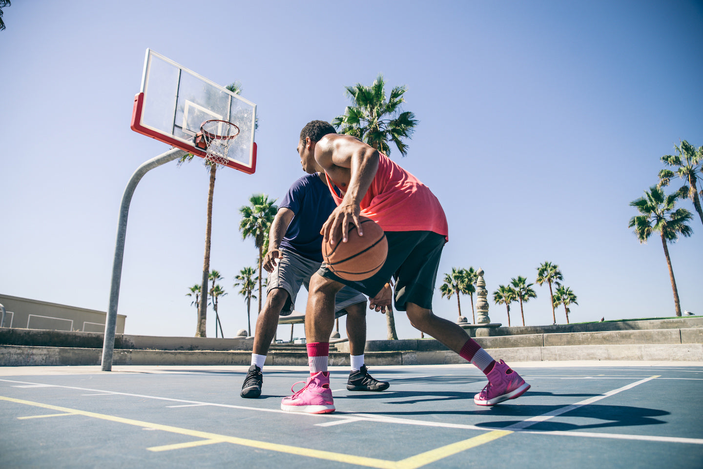 Two men playing basketball on an outdoor court